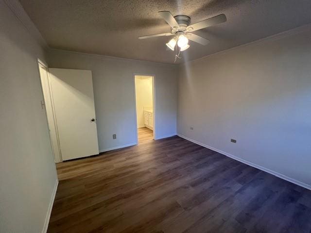 unfurnished bedroom with dark wood-style floors, connected bathroom, baseboards, and a textured ceiling