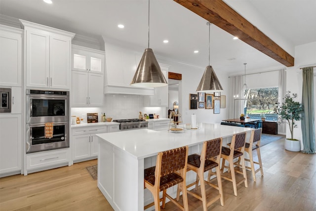 kitchen with white cabinets, beamed ceiling, stainless steel appliances, light wood-style floors, and backsplash