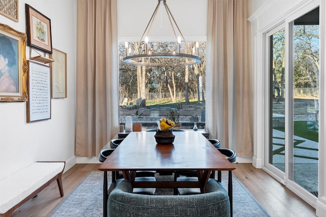 dining space with a chandelier, ornamental molding, and wood finished floors