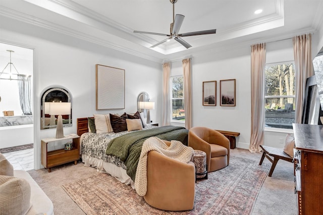 bedroom with ensuite bathroom, recessed lighting, light colored carpet, ornamental molding, and a tray ceiling