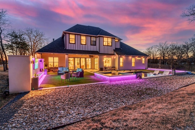 back of house featuring a fenced in pool, a patio, fence, an outdoor living space, and board and batten siding