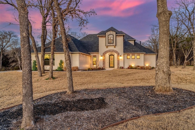 view of front of property featuring a shingled roof and stucco siding