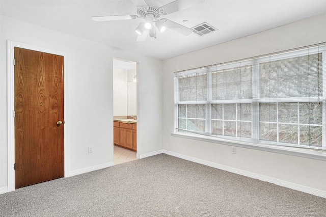 spare room with visible vents, light colored carpet, a ceiling fan, and baseboards