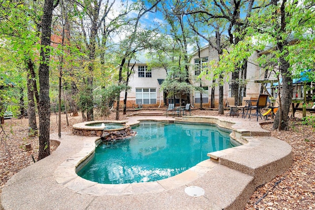 view of pool with a patio and a pool with connected hot tub