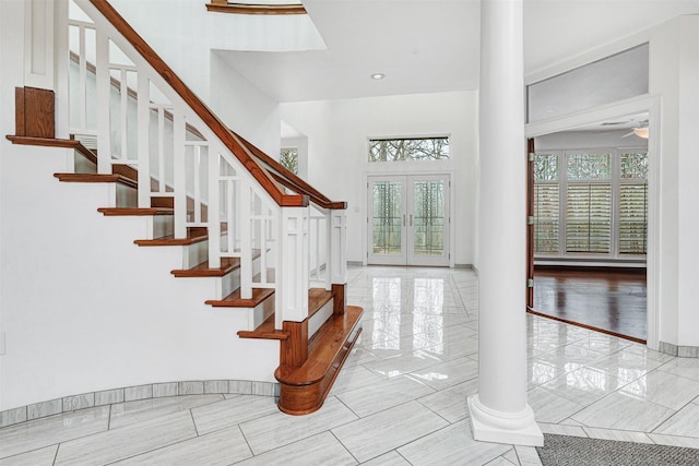 staircase with french doors, plenty of natural light, baseboards, and a ceiling fan