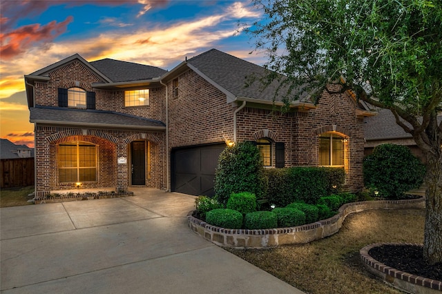 traditional-style house with brick siding, roof with shingles, and concrete driveway