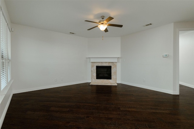 unfurnished living room featuring visible vents, baseboards, dark wood-type flooring, and a fireplace