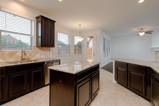 kitchen featuring backsplash, ceiling fan, dishwasher, light stone counters, and a sink