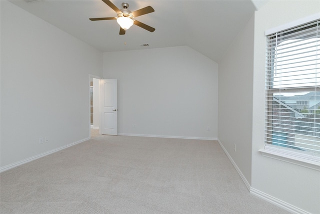 interior space with visible vents, baseboards, vaulted ceiling, light carpet, and a ceiling fan