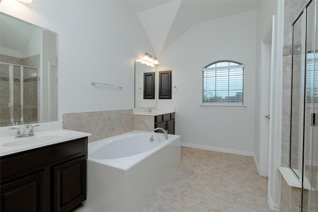 bathroom with a garden tub, two vanities, lofted ceiling, a stall shower, and a sink