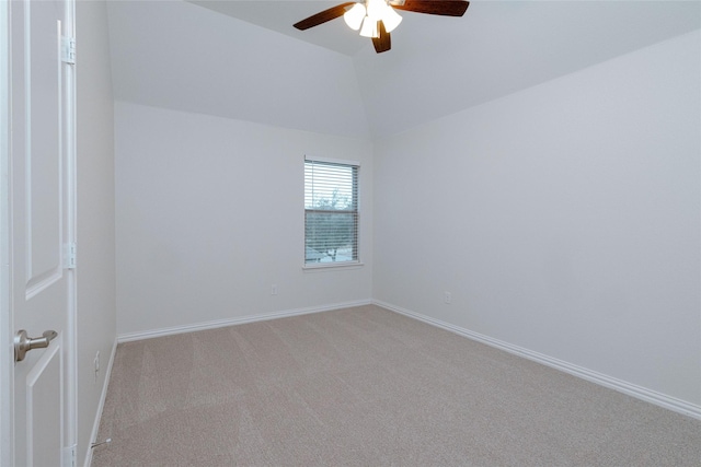 empty room featuring vaulted ceiling, a ceiling fan, baseboards, and light carpet