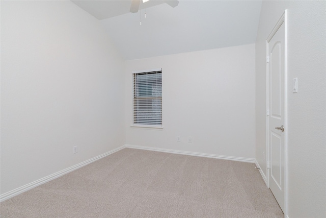 spare room with lofted ceiling, light colored carpet, baseboards, and ceiling fan