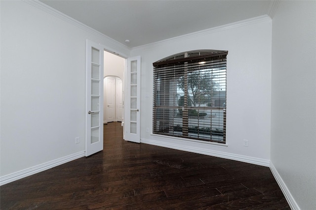 spare room featuring built in features, baseboards, wood finished floors, and ornamental molding