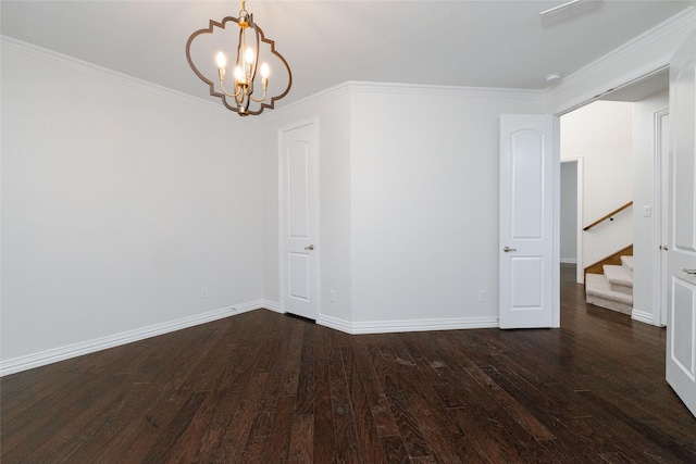 spare room featuring an inviting chandelier, baseboards, dark wood-style flooring, and ornamental molding