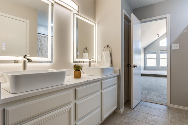 bathroom featuring tile patterned flooring, double vanity, and a sink