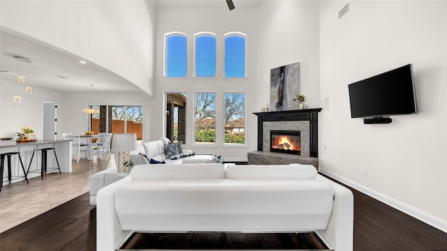 interior space with dark wood-style floors, visible vents, a fireplace, and baseboards