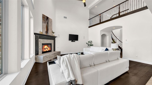 living room with hardwood / wood-style flooring, a premium fireplace, visible vents, baseboards, and stairway