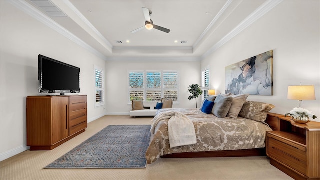 bedroom featuring light carpet, baseboards, a tray ceiling, and crown molding