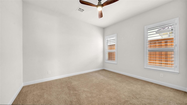 spare room featuring baseboards, carpet, visible vents, and a ceiling fan