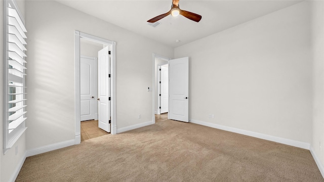 unfurnished bedroom featuring light carpet and baseboards