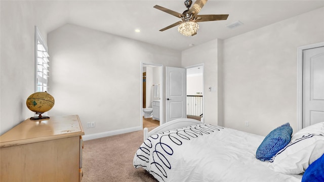 bedroom with carpet, visible vents, vaulted ceiling, ensuite bath, and baseboards