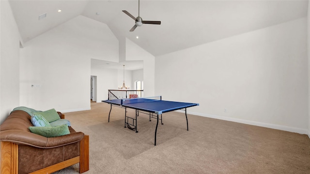 playroom with ceiling fan with notable chandelier, carpet floors, high vaulted ceiling, and baseboards