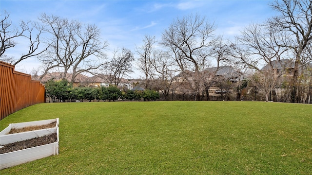 view of yard featuring fence and a garden