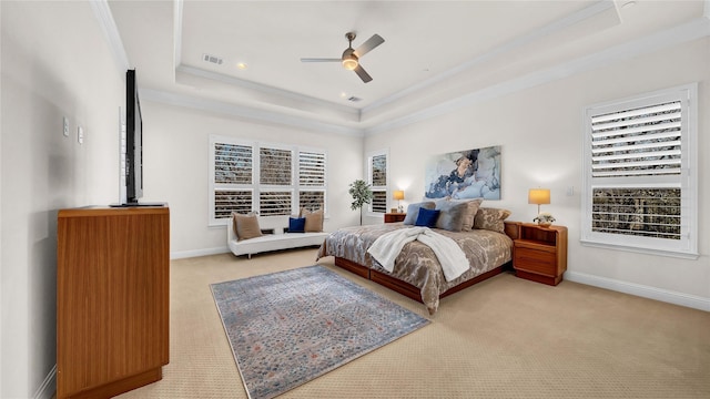 carpeted bedroom with baseboards, a tray ceiling, visible vents, and crown molding