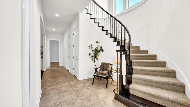 staircase with tile patterned flooring, baseboards, and recessed lighting