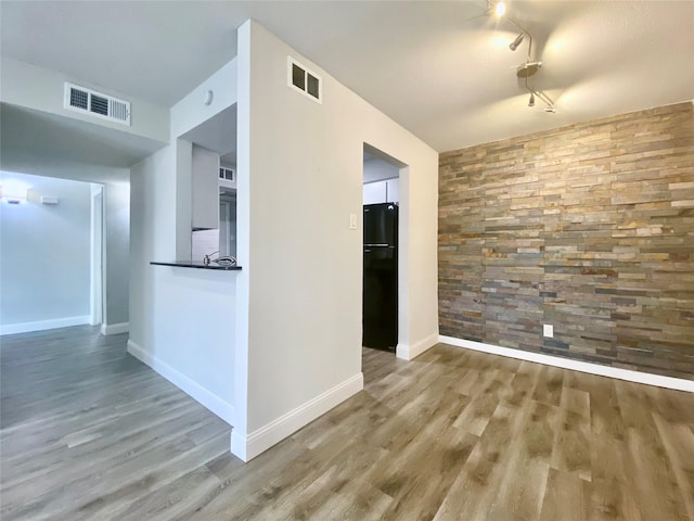 empty room with visible vents, baseboards, and wood finished floors