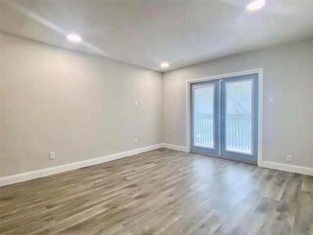 unfurnished room featuring recessed lighting, baseboards, wood finished floors, and french doors