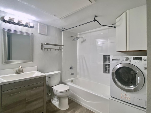 full bath with toilet, wood finished floors, vanity,  shower combination, and washer / dryer