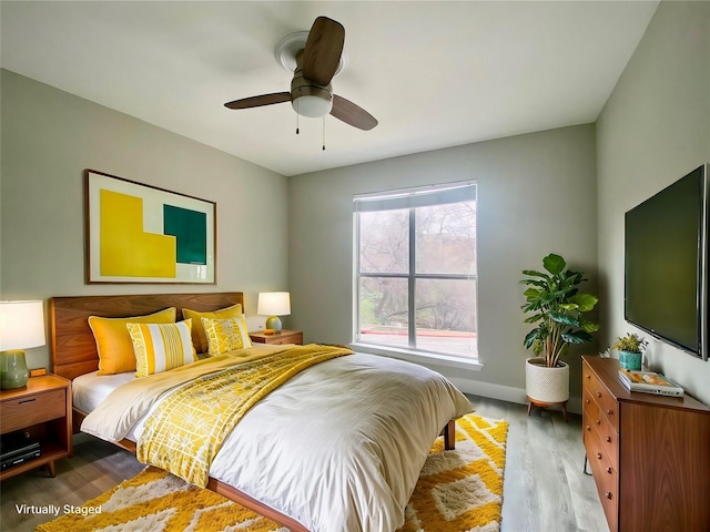 bedroom with ceiling fan, baseboards, and wood finished floors