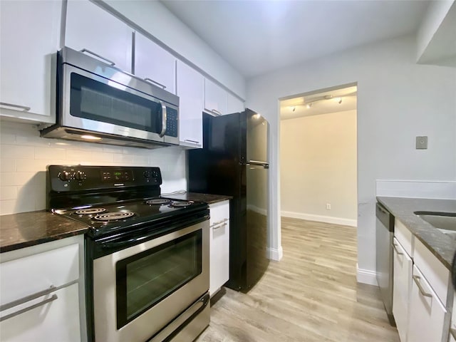 kitchen featuring appliances with stainless steel finishes, light wood-style floors, white cabinets, and decorative backsplash