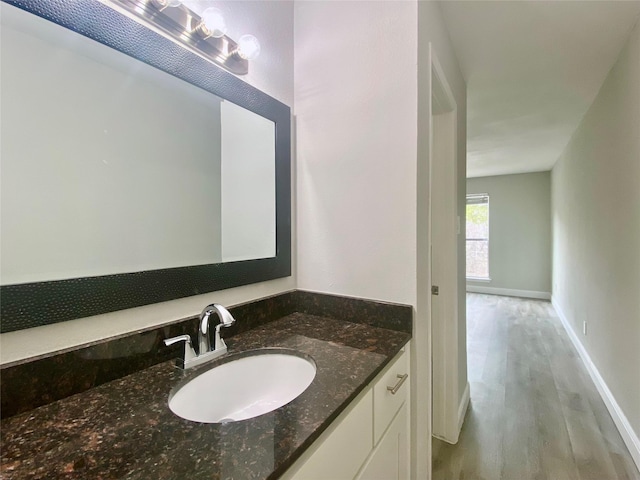 bathroom with vanity, baseboards, and wood finished floors