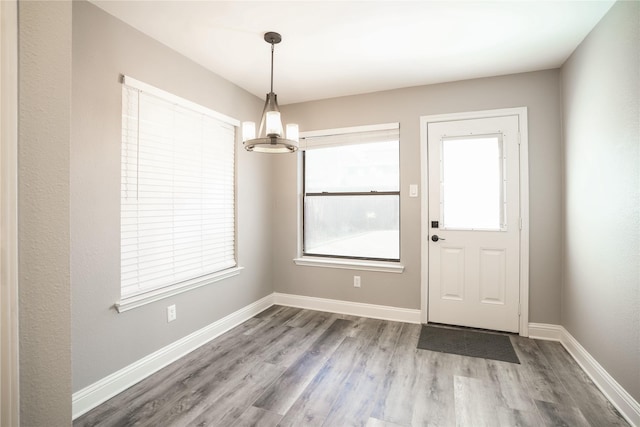 interior space featuring a chandelier, baseboards, and wood finished floors