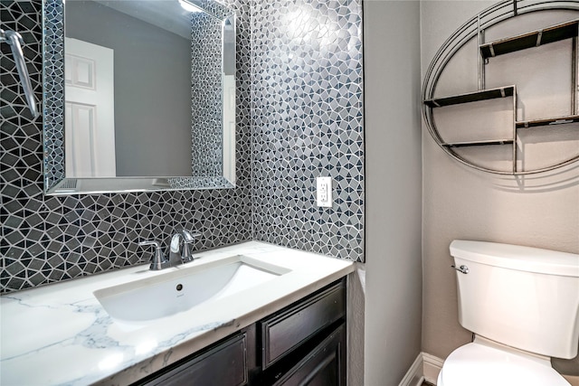 bathroom with vanity, toilet, and decorative backsplash