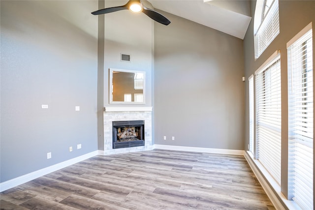 unfurnished living room featuring baseboards, visible vents, wood finished floors, and a tile fireplace