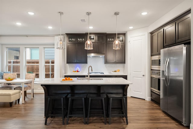 kitchen featuring dark brown cabinetry, visible vents, stainless steel appliances, light countertops, and a sink