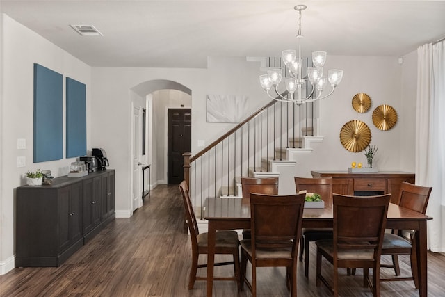 dining room with arched walkways, visible vents, dark wood finished floors, and stairway