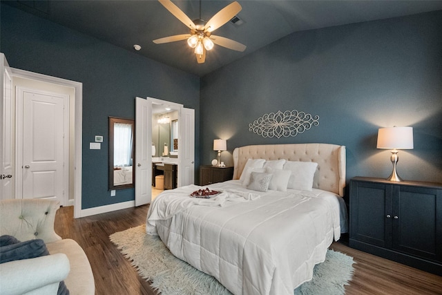 bedroom with lofted ceiling, ensuite bathroom, wood finished floors, visible vents, and baseboards