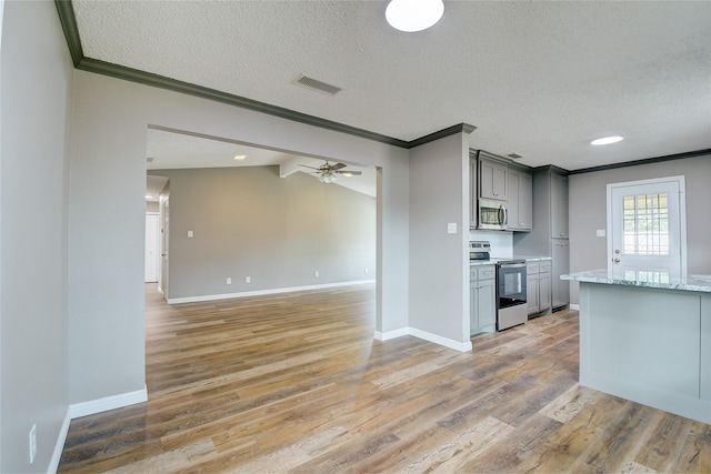 kitchen with appliances with stainless steel finishes, gray cabinets, crown molding, and light wood finished floors