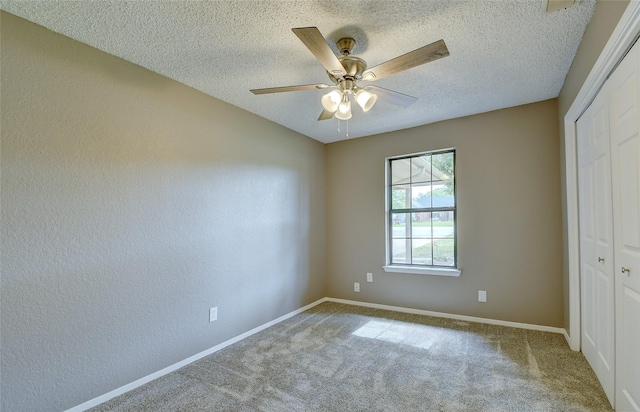 unfurnished bedroom featuring a textured ceiling, a closet, carpet, and baseboards