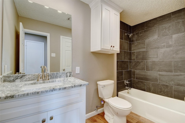 full bathroom with toilet, wood finished floors, bathtub / shower combination, a textured ceiling, and vanity