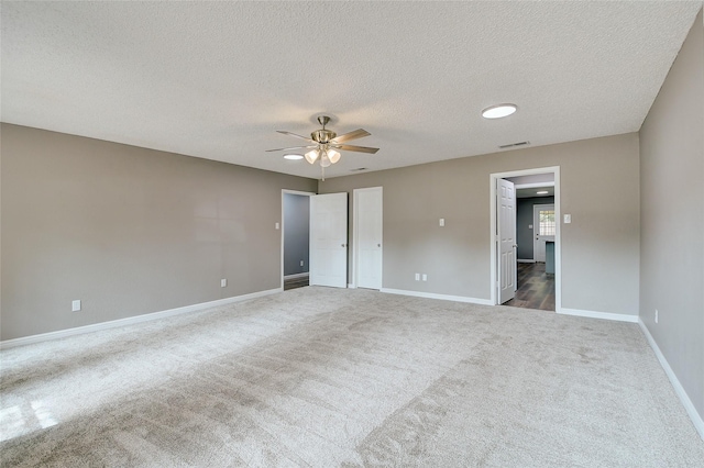 unfurnished bedroom featuring carpet floors, visible vents, ceiling fan, a textured ceiling, and baseboards