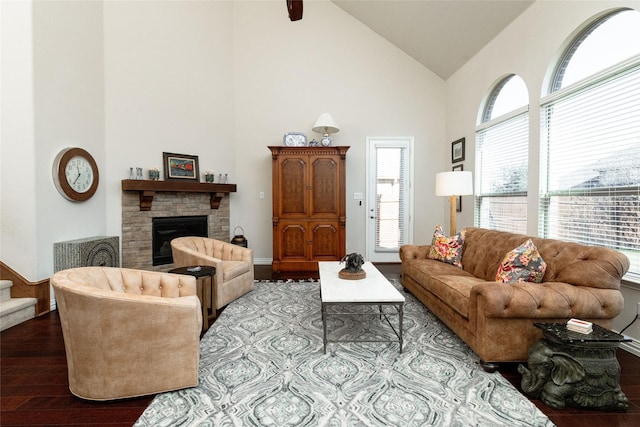 living room with a stone fireplace, high vaulted ceiling, stairs, and wood finished floors