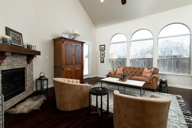 living room featuring baseboards, high vaulted ceiling, a fireplace, ceiling fan, and dark wood-type flooring