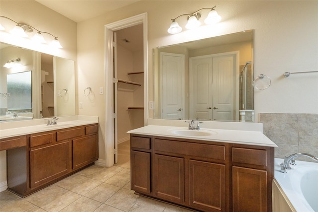 bathroom featuring a sink, two vanities, a bath, and tile patterned floors