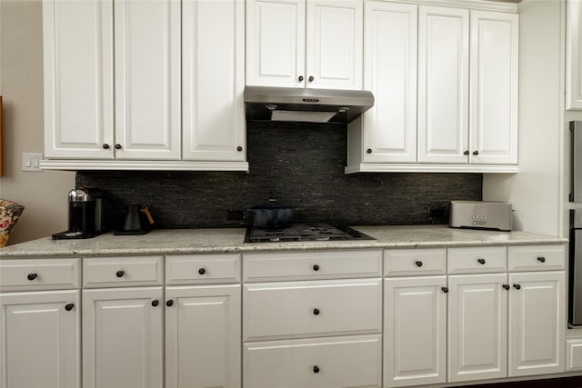 kitchen featuring white cabinetry, backsplash, and under cabinet range hood