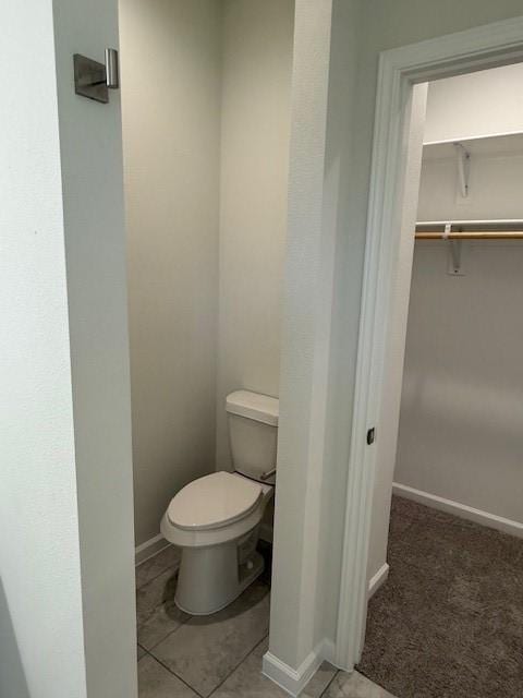 bathroom featuring toilet and baseboards